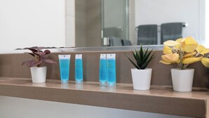 A reception area with a counter displaying potted plants and a mirror reflecting the interior. - 1BR Universal Studios Pool Gym Parking (North Hollywood)