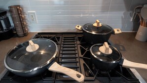 A kitchen with a stove, two pots with lids, and a wooden utensil holder. - 1BR Universal Studios Pool Gym Parking (North Hollywood)