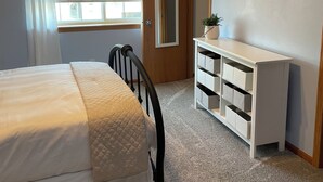 A bedroom with a bed, a dresser, a mirror, a window with blinds, and a door. - Executive home in Private HOA near Amusement Parks. 2 Master Bedrooms - Sleeps 6 (Waterloo)