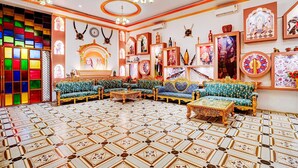 A room with patterned flooring, sofas, a chandelier, and wall decorations. - Deluxehotel Banaras Kila (Pindra)