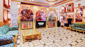 A luxurious interior with ornate sofas, a patterned floor, and a central display with framed artwork. - Deluxehotel Banaras Kila (Pindra)