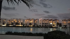 A resort with multiple-story buildings, a swimming pool, and palm trees. - Beautiful apartment for rent in Punta Cana, the Beach-Cristal Lagoon (Punta Cana)