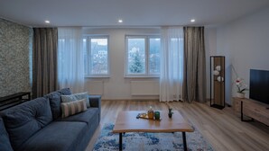Un salon moderne avec un canapé, une table basse et un téléviseur.