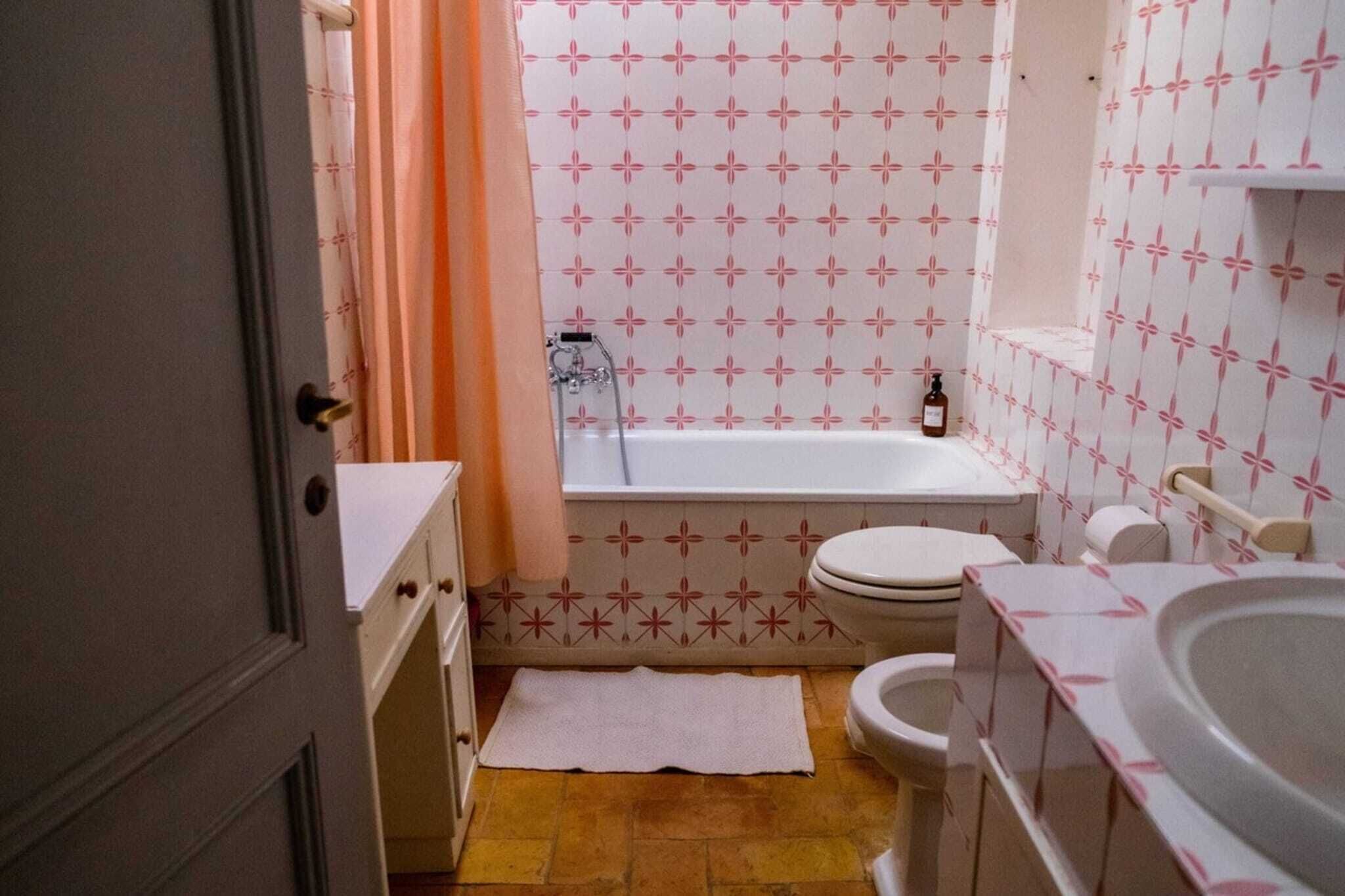 A bathroom with a bathtub, toilet, and sink.