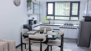 Une cuisine compacte comprenant un coin repas, un réfrigérateur et une fenêtre donnant sur un beau paysage.