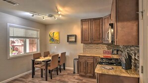 A kitchen with wooden cabinets, a dining table with chairs, a backsplash, and a window with blinds. -  Adison Gold: 2BR w/ Fully Fenced Yard, Barbecue and pet friendly, Near Downtown (Carmichael)