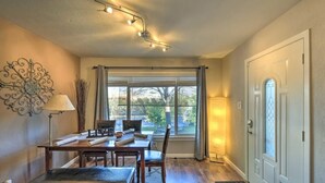 A dining area with a table, chairs, and a window with curtains. -  Adison Gold: 2BR w/ Fully Fenced Yard, Barbecue and pet friendly, Near Downtown (Carmichael)