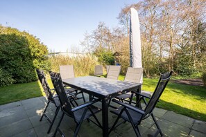 An outdoor patio with a rectangular table and four chairs. - Luxury, Peace and Space for the Whole Family (De Koog)