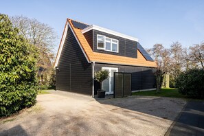 A modern house with a sloped roof, a small front porch, and a solar panel. - Luxury, Peace and Space for the Whole Family (De Koog)