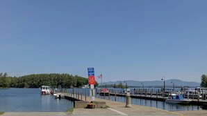 Ein Yachthafen mit vertäuten Booten, einem Bereich für Jetskis und einem wolkenlosen Himmel.