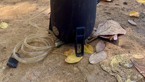 A black water container with a hose and a black cap on the ground. - Fully equipped car to discover the whole island with ease (Les Abymes)