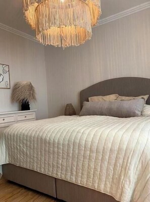 A bedroom with a bed, bedside table, lamp, and a hanging light fixture. - Spacious 3-bedroom apartment in peaceful Ginsheim-Gustavsburg with AC (Ginsheim-Gustavsburg)