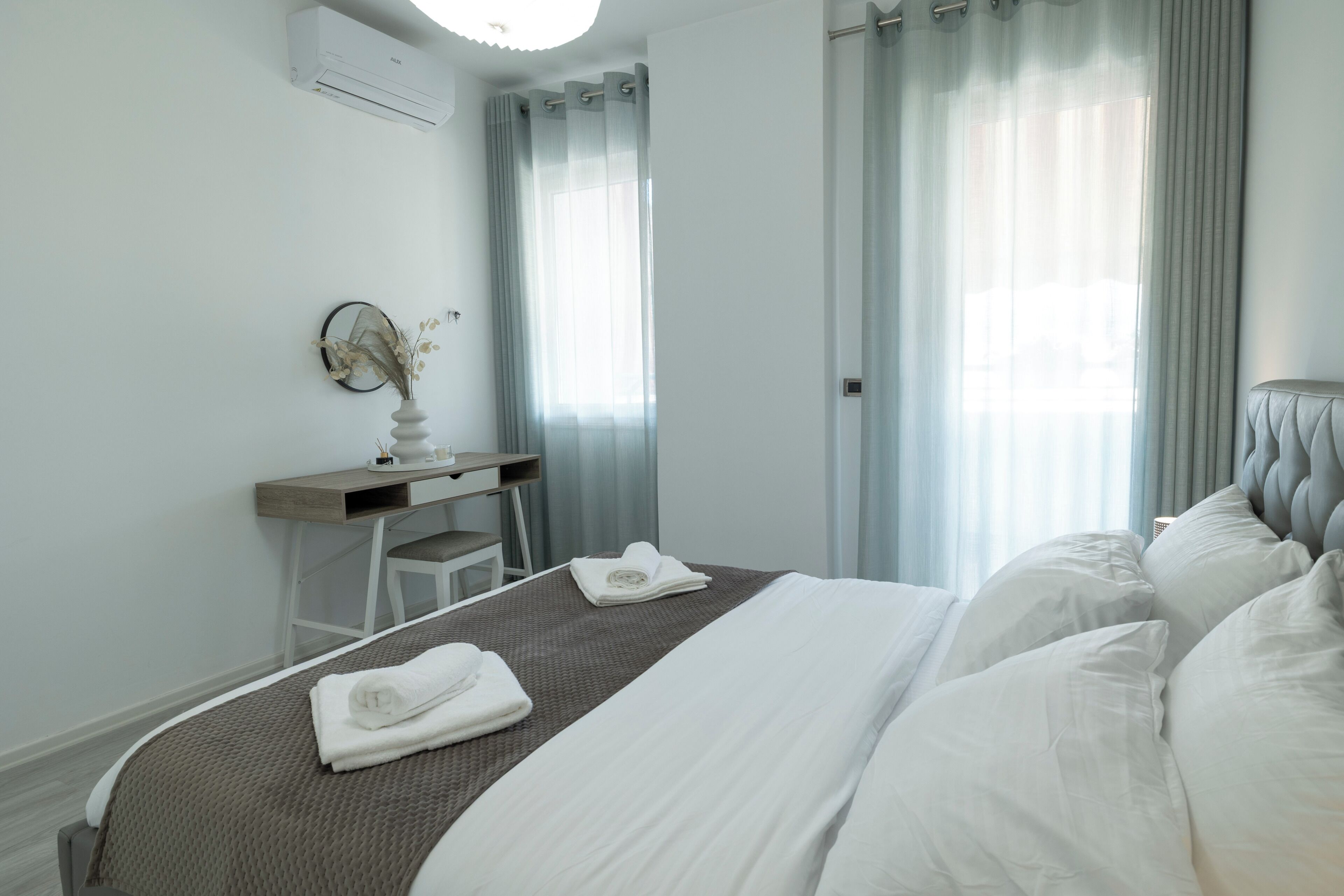Ein Hotelzimmer mit Bett, Schreibtisch, Stuhl und einer Wandklimaanlage.