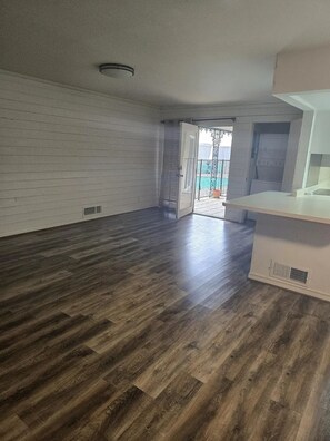 An empty room with wooden flooring, a white wall, and a door leading outside. - 11 bedrooms! The Perfect World Cup Stay for Large Groups! (Dallas)