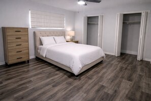 A bedroom with a bed, a nightstand, a dresser, a ceiling fan, and a walk-in closet. - 11 bedrooms! The Perfect World Cup Stay for Large Groups! (Dallas)
