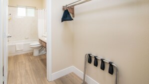 A bathroom with a bathtub, toilet, and a towel rack.