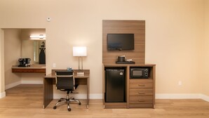 A hotel room with a wooden desk, a chair, a flat-screen TV, a mini-fridge, a microwave, and a coffee maker. - 2 Queen Bed Room- Handicap (Pollock Pines)