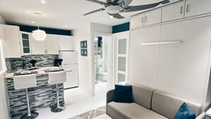 Ein modernes Wohnzimmer mit einer Couch, einem Couchtisch und einem Deckenventilator.