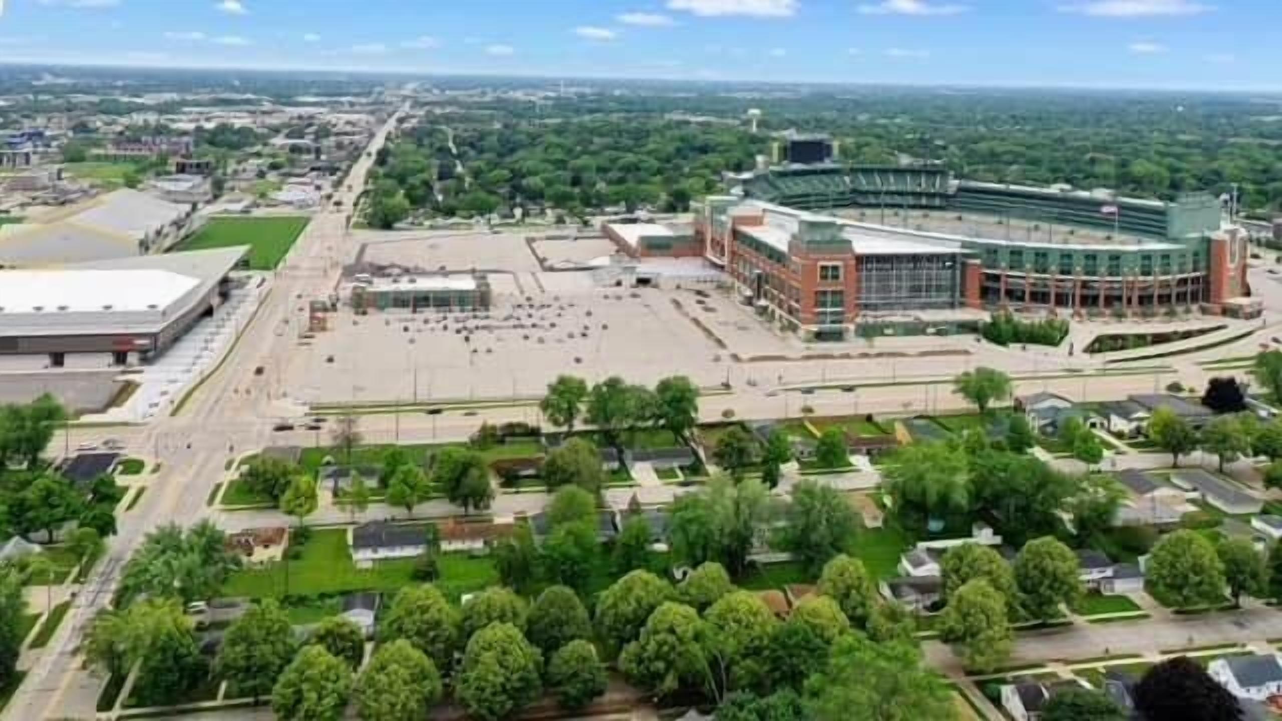An aerial view of a campus with a large stadium, green spaces, and residential areas.