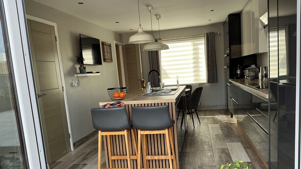 A modern kitchen with a central island, bar stools, and a dining area. - Take a Break. Cozy Double Room. Very modern home. Full use of Bathroom,Kitchen (Leyland)
