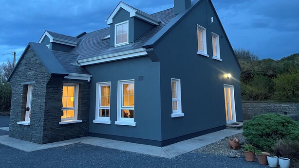 A modern two-story house with a stone facade, multiple windows, and a chimney. - Peaceful family hideaway near Doolin with Aran views & stunning sunsets. (Doolin)