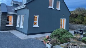 A modern two-story house with a dark exterior, white trim, and multiple windows. - Peaceful family hideaway near Doolin with Aran views & stunning sunsets. (Doolin)