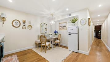 A modern kitchen with a white refrigerator, wooden cabinets, and a dining area with a table and chairs.