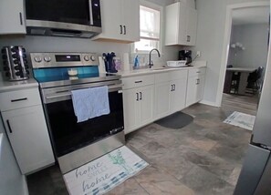 A kitchen with white cabinets, a stove, a sink, and a refrigerator. - Spacious Country Retreat – Perfect for Families, Groups & Getaways (Plattsburgh)