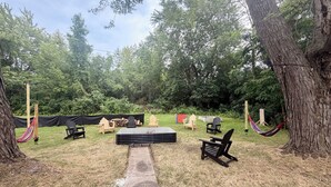Een buitenzitplaats met stoelen en een tafel, omringd door bomen.