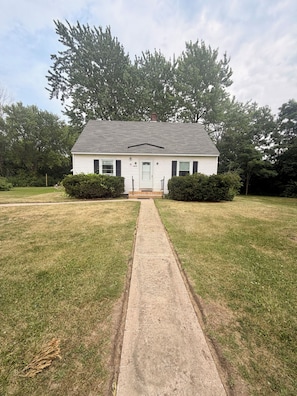 A single-story house with a front porch, a driveway leading to the entrance, and a well-maintained lawn. - Spacious Country Retreat – Perfect for Families, Groups & Getaways (Plattsburgh)