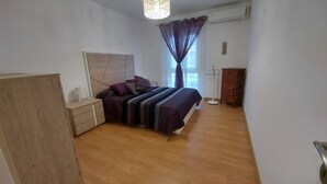 A bedroom with a bed, bedside tables, a wardrobe, and a window with curtains. - Bright apartment in Los Llanos downtown (Los Llanos)