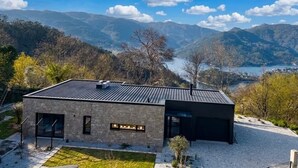 Un edificio moderno con fachada de piedra, ventanas amplias y techo plano.