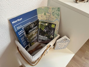 Manden met een brochure, een kaart en een houten lepel met 'Sloveen Maribor' gegraveerd.