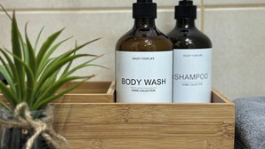 A wooden box containing two bottles of body wash and shampoo. - Small and cozy apartment｜Free parking (Maribor)
