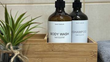 Een houten doosje met twee flesjes douche- en shampoobad.