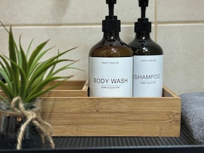 A wooden box containing two bottles of body wash and shampoo.