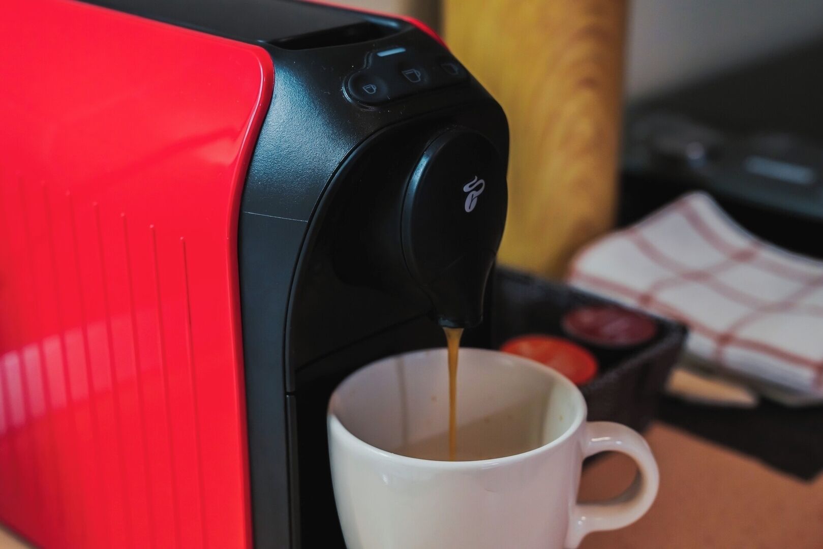 A coffee machine dispensing coffee into a white mug.