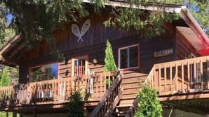 A wooden cabin with a balcony, a staircase, and a number '1490' sign. - Chalet Du Nord (Saint-Adolphe-d'Howard)