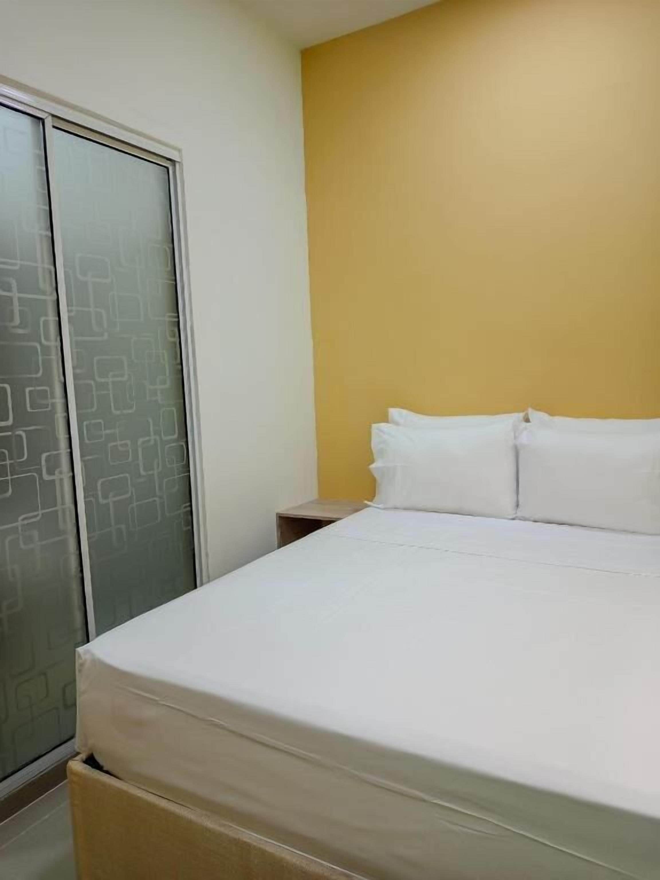 A bedroom with a bed, a nightstand, and a wardrobe with a geometric pattern.