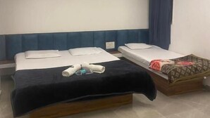 Une chambre d’hôtel avec deux lits, un ventilateur de plafond et une fenêtre avec des rideaux.