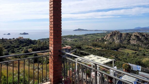 A balcony with a view of the sea, a brick pillar, and a metal railing. - Vacation apartment in Santa Maria Navarrese, beautiful view (Santa Maria Navarrese)