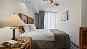 A hotel room with a bed, a desk with a lamp, a telephone, a ceiling fan, and a window with curtains. - Honolulu Marathon 12/13/26
Prime Waikiki Beach, heart of marathon festivities (Honolulu)