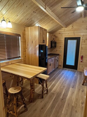 Un interior de madera con cocina, comedor y ventilador de techo.