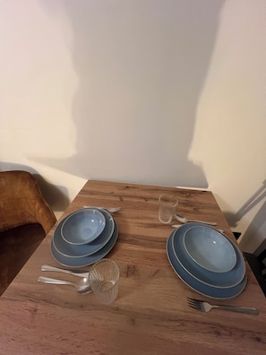 A dining table with blue plates, cutlery, and a glass. - Forest & Wind - Nature Meets Modernity (Marburg)