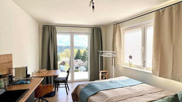 Une chambre à coucher moderne avec un lit, un bureau et une chaise.