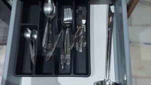 A drawer with a set of silverware including spoons, forks, knives, and a ladle. - Quiet, Modern Studio Apartment in Zenata with Pool View (Âïn-Harrouda)