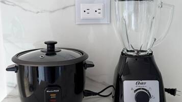 A MasterMaid slow cooker and an Oster blender on a marble countertop.