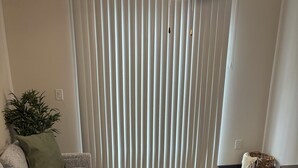 A living room with a sofa, a coffee table, a potted plant, and a window with vertical blinds. - Welcome to your home away from home. A calm, escape designed for pure relaxation (Decatur)
