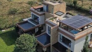 Una casa moderna a più piani con tetto piatto, ampie finestre e pannelli solari.