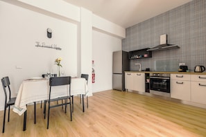Eine moderne Küche mit Einbauofen, ein Essbereich mit Tisch und Stühlen sowie ein an der Wand befestigtes Schild.